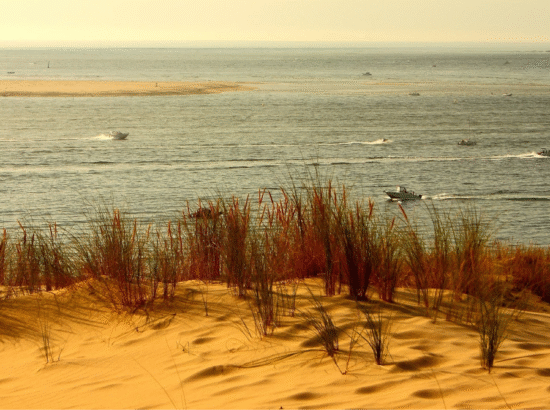 Vue depuis les dunes sur le Bassin d'Arcachon et ses bateaux, un spot idéal pour une balade sur la plage lors d'un séjour